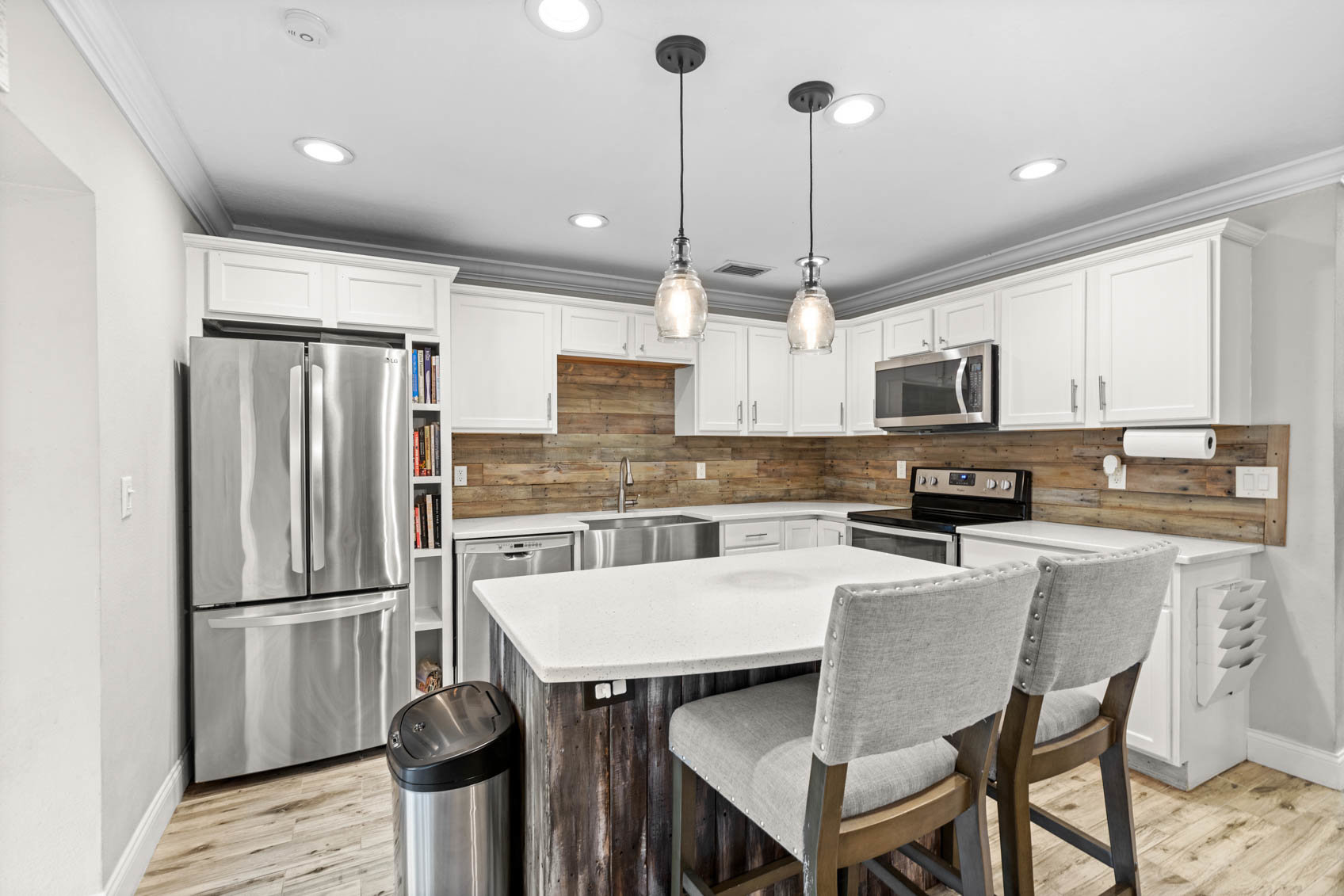 kitchen with white marble island and wooden backsplash